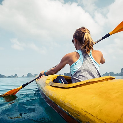 Blonde woman kayaking on cloudy day