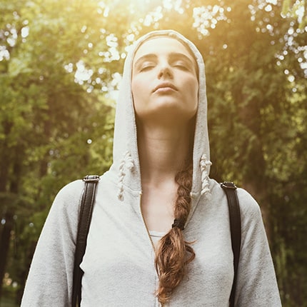 Young white female having mindfulness experience in the woods